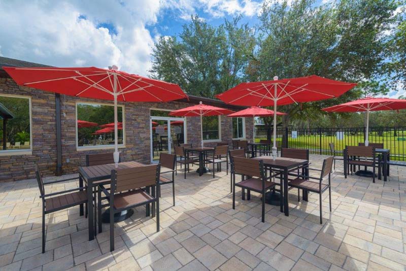 Patio with dining tables under red umbrellas 